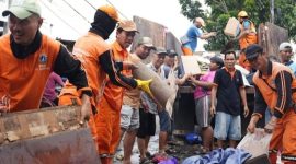 Pemerintah Kota (Pemkot) Administrasi Jakarta Barat mengerahkan puluhan truk dan ratusan personel gabungan bersama warga untuk membersihkan sampah pascabanjir secara serentak di delapan kecamatan, Minggu (25/1/2026).