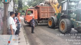 Lurah Kapuk, M. Arief Budiman, turun langsung memimpin kegiatan pembersihan tumpukan sampah di jalan tanggul timur