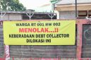 Spanduk penolakan terhadap aktivitas debt collector terpasang di kawasan RT 001/RW 002 sebagai bentuk aspirasi warga yang menginginkan lingkungan tetap aman, tertib, dan bebas dari potensi keributan di ruang publik. Warga berharap setiap proses penagihan pembiayaan dilakukan sesuai ketentuan hukum tanpa mengganggu ketertiban masyarakat.
Foto: Dok. Tikampost.id.