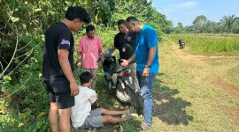 Petugas bersama sejumlah warga terlihat berada di lokasi saat melakukan pemeriksaan terhadap seorang pria dan sepeda motor di kawasan jalan perkebunan. Pemeriksaan tersebut diduga berkaitan dengan pengungkapan kasus yang tengah ditangani aparat. (Dok: Tikampost.id)