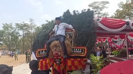 Kadis Kominfo Way Kanan, Yusron Lutfi, S.H., M.M., turut menaiki Dadak Merak dalam pertunjukan Reog Ponorogo pada rangkaian peringatan HUT ke-81 Kemerdekaan Republik Indonesia di Kabupaten Way Kanan, Senin (17/8/2026). Aksi tersebut mendapat sambutan meriah dan tepuk tangan dari masyarakat serta tamu undangan yang hadir.