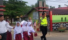 Kapolres Dharmasraya Turun Langsung Bantu Siswa Menyeberang Jalan di Depan SDN 2 Sitiung