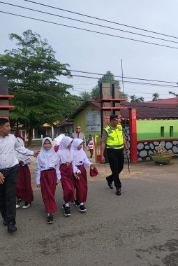 Kapolres Dharmasraya Turun Langsung Bantu Siswa Menyeberang Jalan di Depan SDN 2 Sitiung
