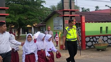 Kapolres Dharmasraya Turun Langsung Bantu Siswa Menyeberang Jalan di Depan SDN 2 Sitiung