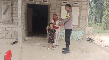 Bhabinkamtibmas Nagari Sipangkur, Bripka Afri Arianto, menyalurkan zakat bulanan kepada Aci Susilawati, warga Jorong Sipangkur I, Nagari Sipangkur, Kecamatan Tiumang, Kabupaten Dharmasraya, Selasa (13/10/2026). (Dok. Polres Dharmasraya)